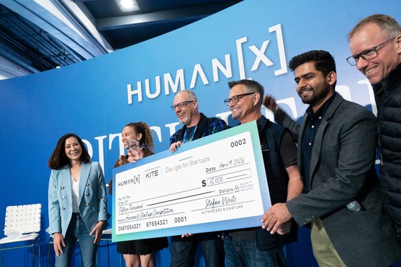 The winners of the pitch competition are holding up a giant check at HumanX San Francisco 2026