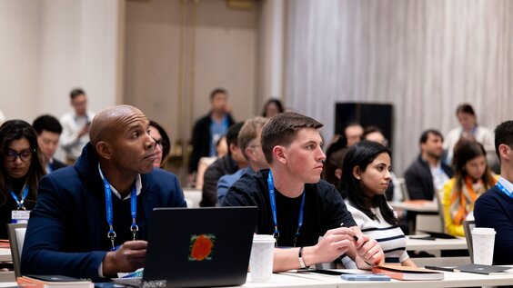 A woman addresses two people at a business meeting.