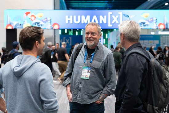 A woman smiles as she greets a man approaching the SolutionBridge desk at HumanX 2026 in San Francisco
