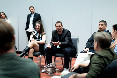 A woman smiles as she greets a man approaching the SolutionBridge desk at HumanX 2026 in San Francisco