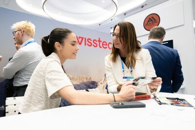 Two women network at a booth on the showfloor at HumanX 2025