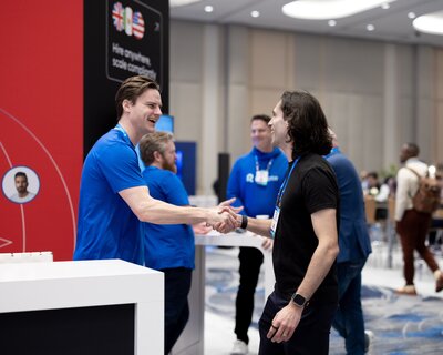 Two men shake hands in greeting on the 2025 HumanX showfloor