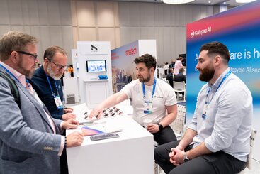 Attendees network at a booth on the showfloor at HumanX 2025